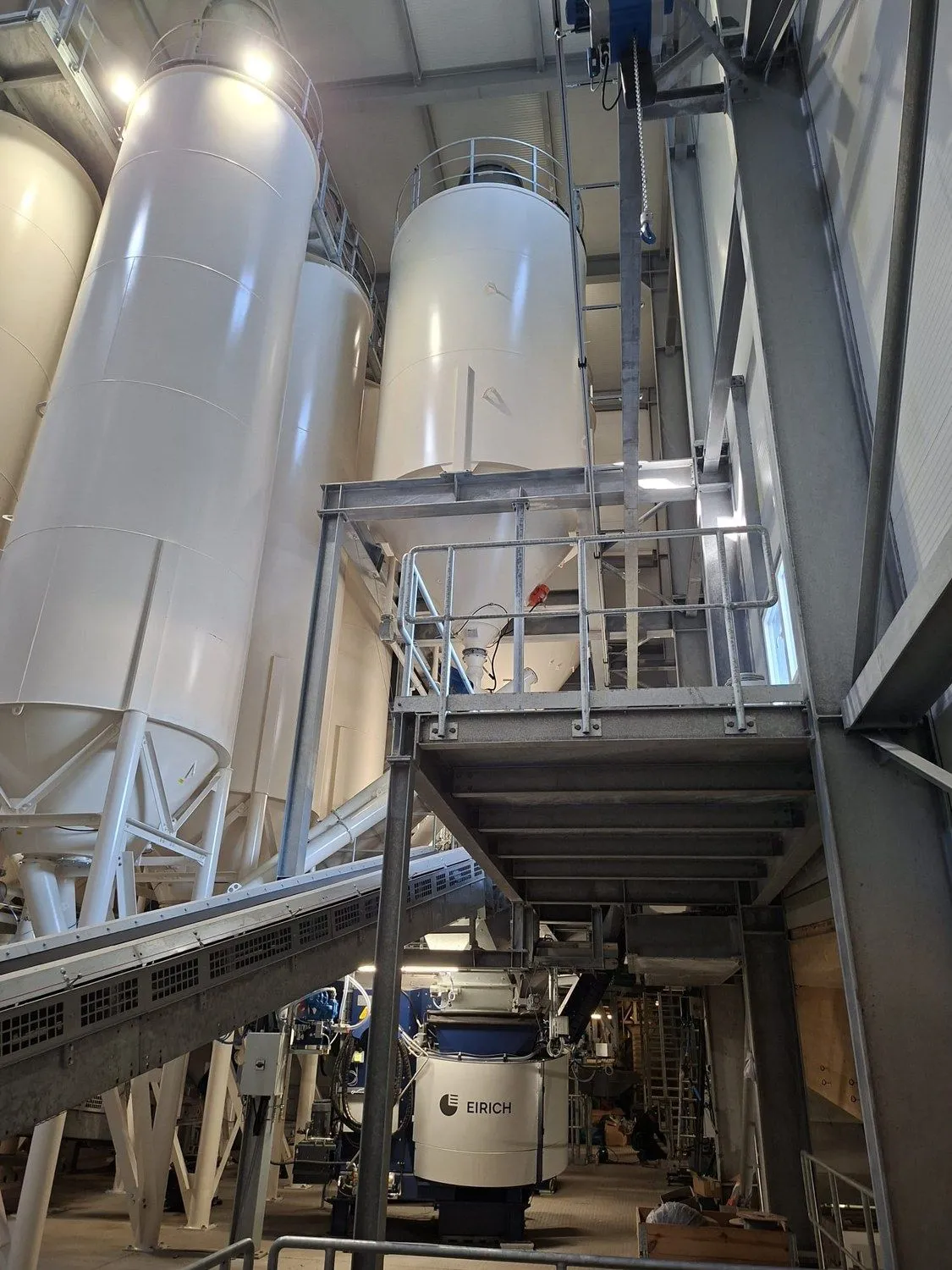Stahlbühne mit Treppe und Geländer zwischen den Silos einer Mischanlage