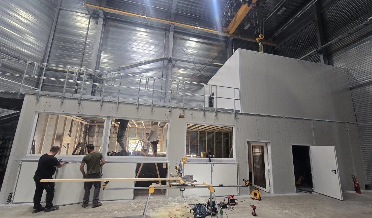 Stahlbau-Montage in einer Industriehalle: Aufbau mit umlaufender Bühne und Geländer